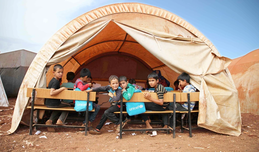 Syrian children who fled violence with their families from the northern countryside of Hama attend a makeshift school in the Atme village, Idlib. (AFP)