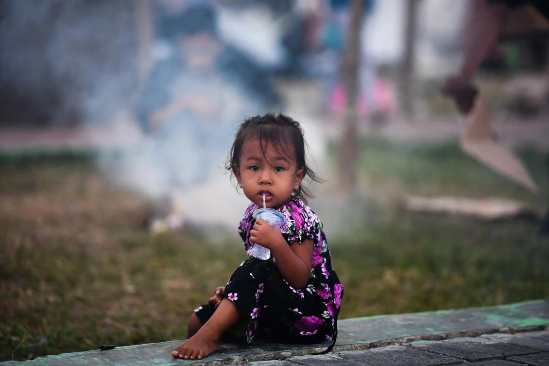 An earthquake-affected child drinks water at a makeshift camp in Palu in Indonesia’s Central Sulawesi on October 4, 2018, following the September 28 earthquake and tsunami. (AFP)