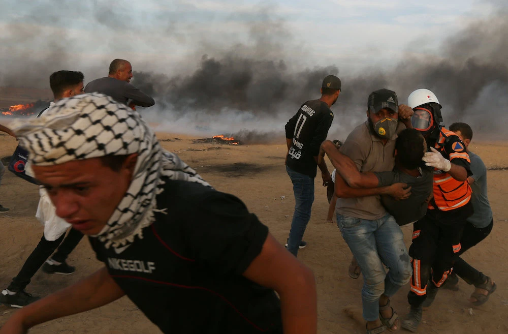 A wounded Palestinian is evacuated during a protest calling for lifting the Israeli blockade on Gaza and demanding the right to return to their homeland. (Reuters)