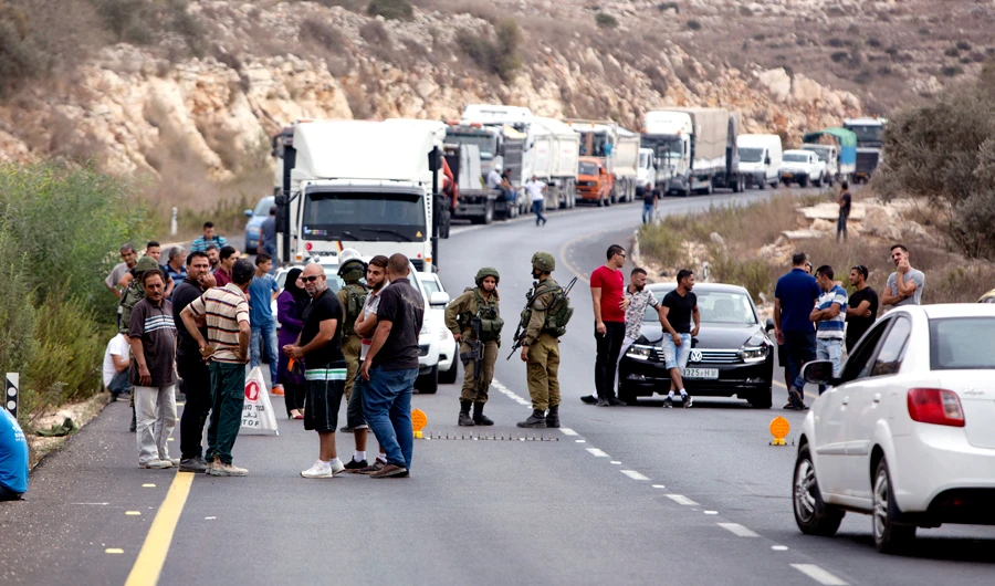 Palestinians wait at an Israeli checkpoint near the scene of a shooting attack at Barkan industrial zone in the West Bank on Sunday, Oct. 7, 2018. (AP)