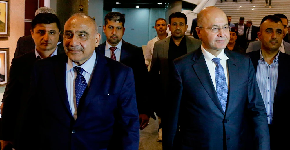 Iraq’s new President Barham Salih, center right, walks with new Prime Minister Adel Abdul Mahdi, center left, in the parliament building. (AP)