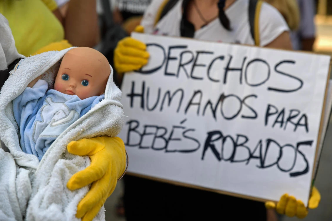 Demonstrators hold baby dolls and placards reading ‘Human rights for stolen babies’ outside a provincial court in Madrid on June 26, on the first day of the first trial over thousands of suspected cases of babies stolen from their mothers during the Franco era. (AFP)