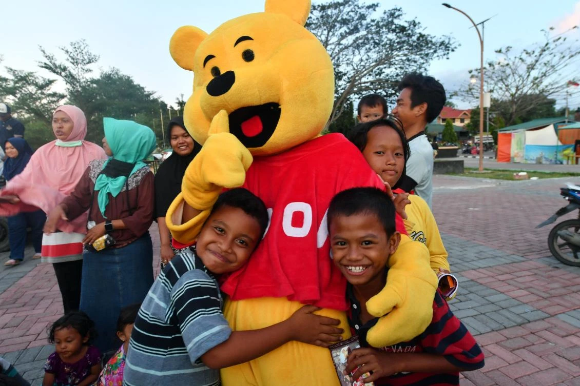Indonesian children hug a Winnie the Pooh character as they attend a trauma healing program at a shelter in Palu on Monday, October 8. (AFP)