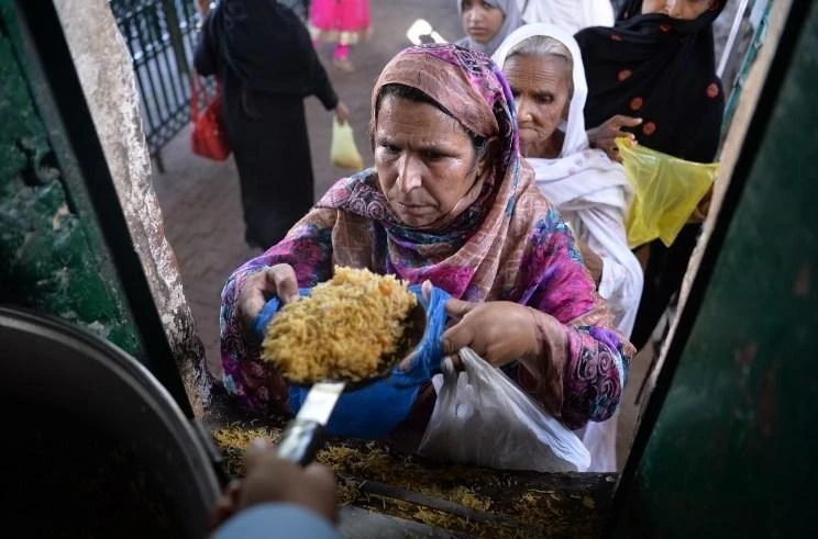 The IMF has called on Pakistan’s new government to act fast to stabilize its teetering economy, warning growth will likely slow and inflation rise. Above, Pakistani woman receives charity food at the Bari Imam shrine in Islamabad. (AFP)