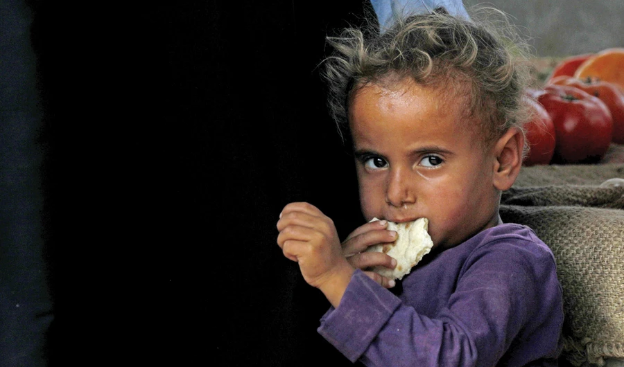 A displaced Syrian child from Deir Ezzor eats a piece of bread at a camp for displaced people in the province of Hasakeh on Monday. (AFP)