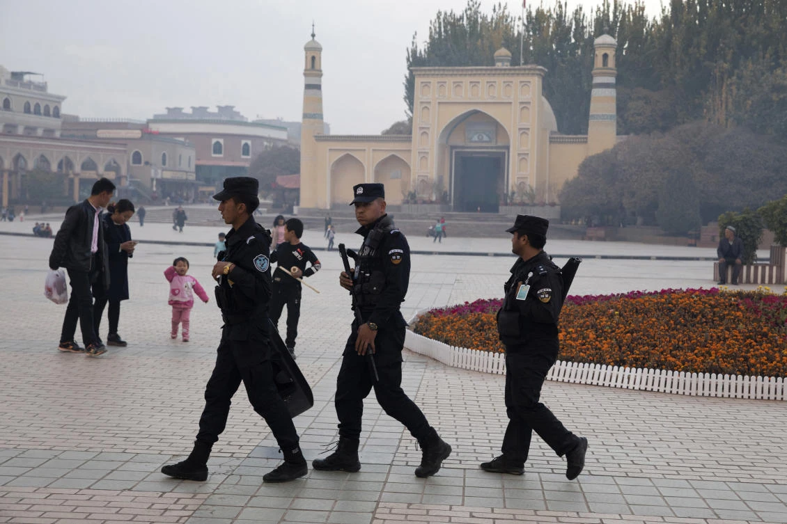 In this Nov. 4, 2017 file photo, Uighur security personnel patrol near the Id Kah Mosque in Kashgar in western China's Xinjiang region. China's northwestern region of Xinjiang has revised legislation to allow the detention of suspected extremists in "education and training centers." (AP)