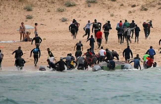 Migrants disembark from a dinghy at "Del Canuelo" beach after they crossed the Strait of Gibraltar sailing from the coast of Morocco, in Tarifa, southern Spain, July 27, 2018. (Reuters)