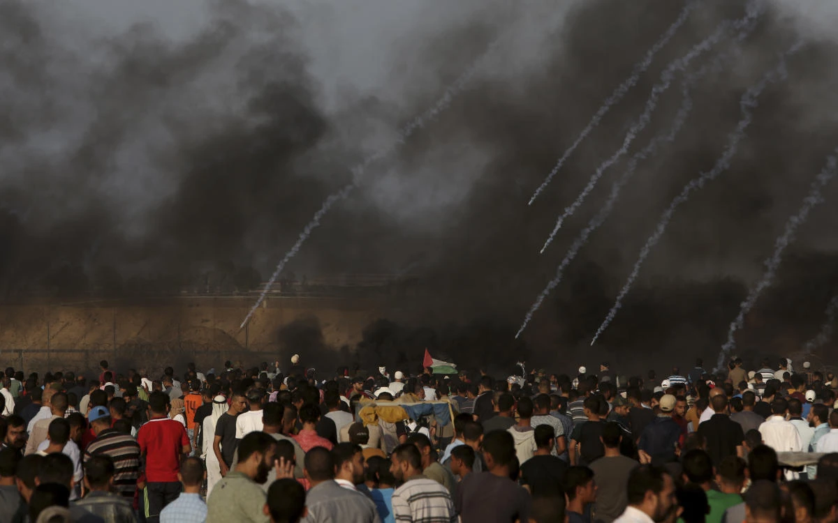 Protesters gather while Israeli troops fire teargas near the fence of Gaza Strip border with Israel during a protest east of Khan Younis, southern Gaza Strip, Friday, Oct. 5, 2018. (AP)