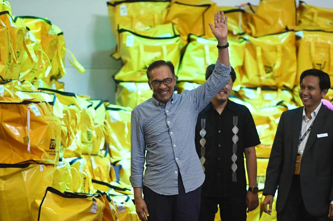 Malaysia's People's Justice Party president and leader of the Pakatan Harapan coalition Anwar Ibrahim waves after winning in a by-election in Port Dickson. (AFP)