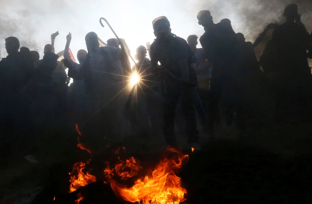 Palestinians gather at the Israel-Gaza border fence during a protest calling for lifting the Israeli blockade on Gaza and demanding the right to return to their homeland, in the southern Gaza Strip on Oct.12, 2018. (REUTERS/Ibraheem Abu Mustafa)
