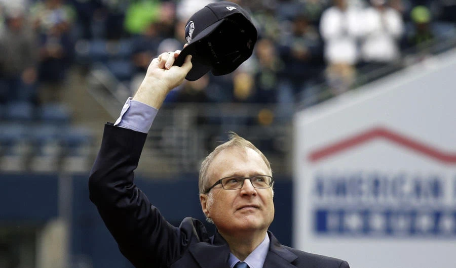 In this Sept. 17, 2017 photo, Seattle Seahawks owner Paul Allen waves as he is honored for his 20 years of team ownership before an NFL football game against the San Francisco 49ers in Seattle. Allen co-founded Microsoft with his childhood friend Bill Gates before becoming a billionaire philanthropist who invested in conservation, space travel, arts and culture and professional sports. (AP Photo/Elaine Thompson)