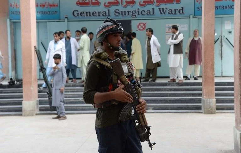 A policeman is on guard as volunteers carry an injured person to a hospital, following an attack that targeted a parliamentary election rally in the eastern province of Nangarhar, in Jalalabad on October 2. (AFP)
