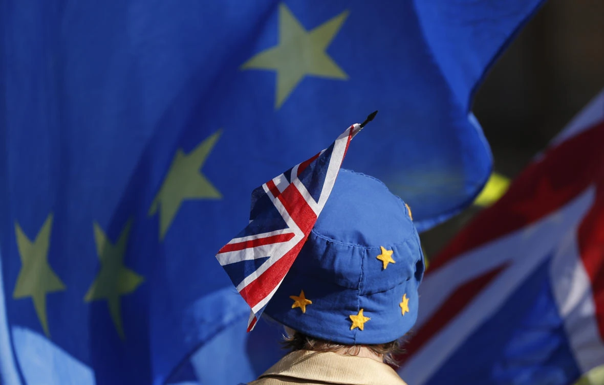 A pro-EU demonstrator wears an EU flag styled as a hat, with a British Union flag pinned to it, outside the Palace of Westminster as the British government holds a cabinet meeting on Brexit inside 10 Downing Street, London, Tuesday, Oct. 16, 2018. (AP)