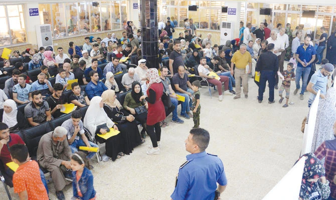 Iraqis wait at the Nineveh governorate building in Iraq's second city of Mosul to resolve issues related to their identity documents. (AFP)