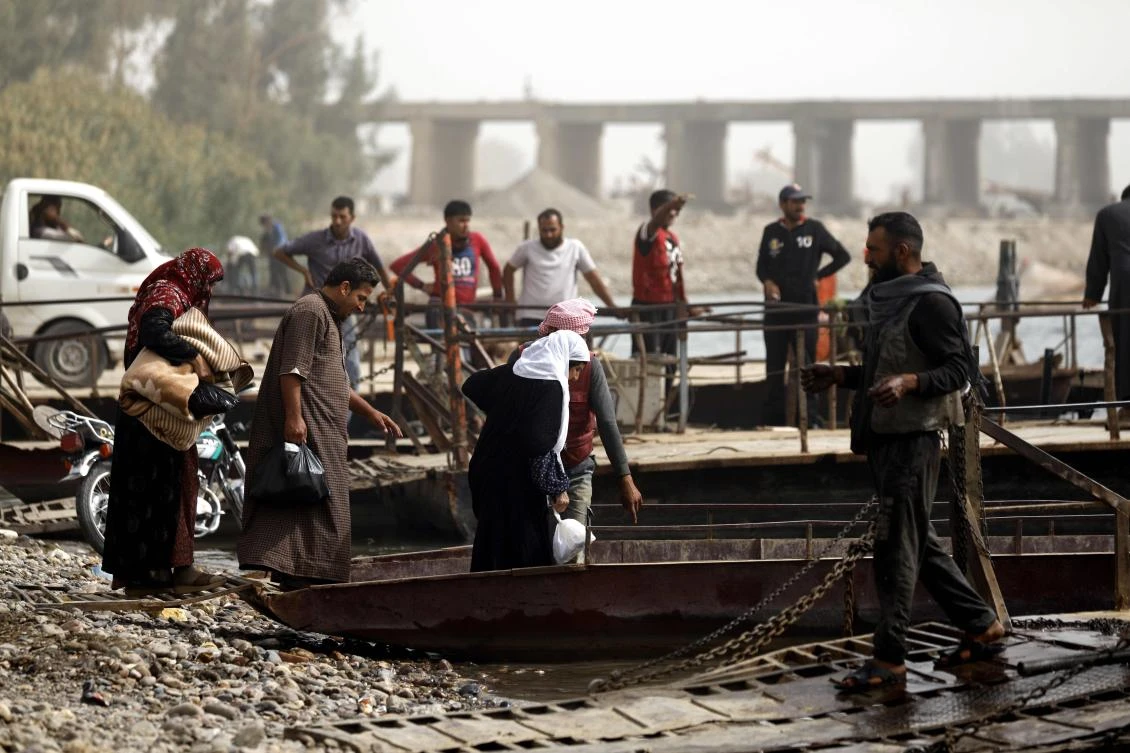 Syrians cross from the city of Raqqa to the countryside villages south of the city on ferries on October 15, 2018, due to the destruction of the bridge connecting the two areas. (AFP / Delil Souleiman)