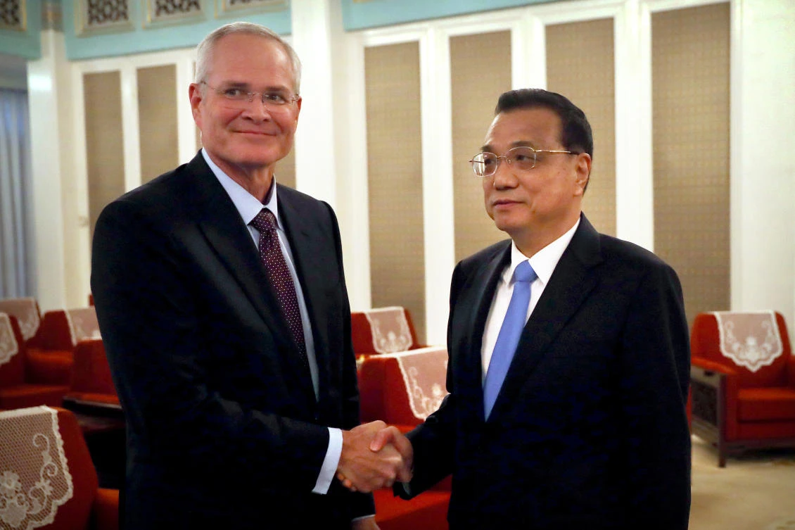 Exxon Mobil CEO Darren Woods with Chinese Premier Li Keqiang. (AFP)