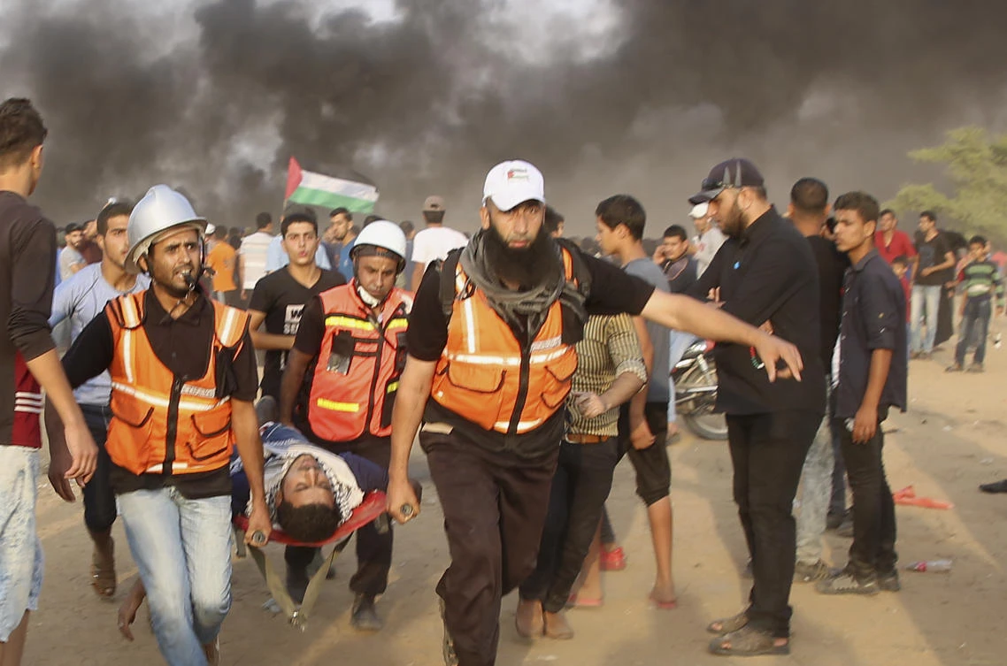 Medics evacuate a wounded youth from near the fence of the Gaza Strip border with Israel during a protest east of Khan Younis, southern Gaza Strip, Friday, Oct. 19, 2018. (AP)