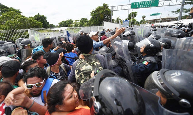 Mexicna Federal Police officers try to prevent Honduran migrants, heading in a caravan to the US, from going through at the Guatemala-Mexico international border bridge in Ciudad Hidalgo, Chiapas state, Mexico, on October 19, 2018. (AFP)