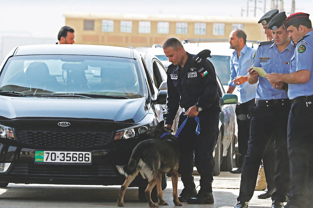 Jordanian police check vehicles at the main border crossing between Jordan and Syria on the day of its reopening on Oct. 15 after a three-year closure. (AFP)