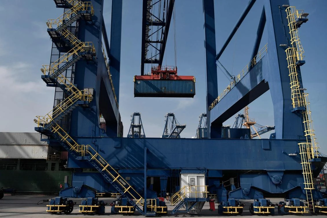 Cranes load a container at the new container terminal in the port of Piraeus in Greece. (AFP)