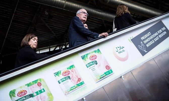 Visitors stand on an escalator on which is displayed an advertisement of Seara halal food products, during the SIAL 2018 (Salon international de l'Alimentation - International Food Fair) on October 21, 2018 in Villepinte, outside Paris. (AFP)