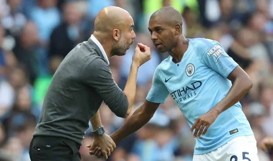 Fernandinho recieves words from his coach Pep Guardiola.