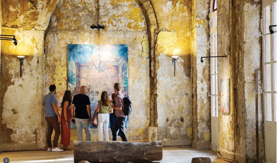 Visitors look at Tom Young’s painting inside the Grand Sofar Hotel, Sawfar, Lebanon, on Sept. 30. (Thomson Reuters)