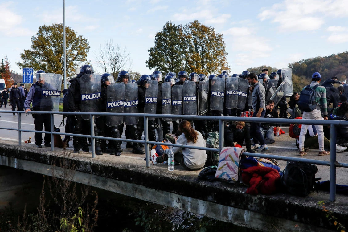 Croatian riot police stand guard in front of migrants at Maljevac border crossing between Bosnia and Croatia near Velika Kladusa, Bosnia, October 24, 2018. (Reuters)