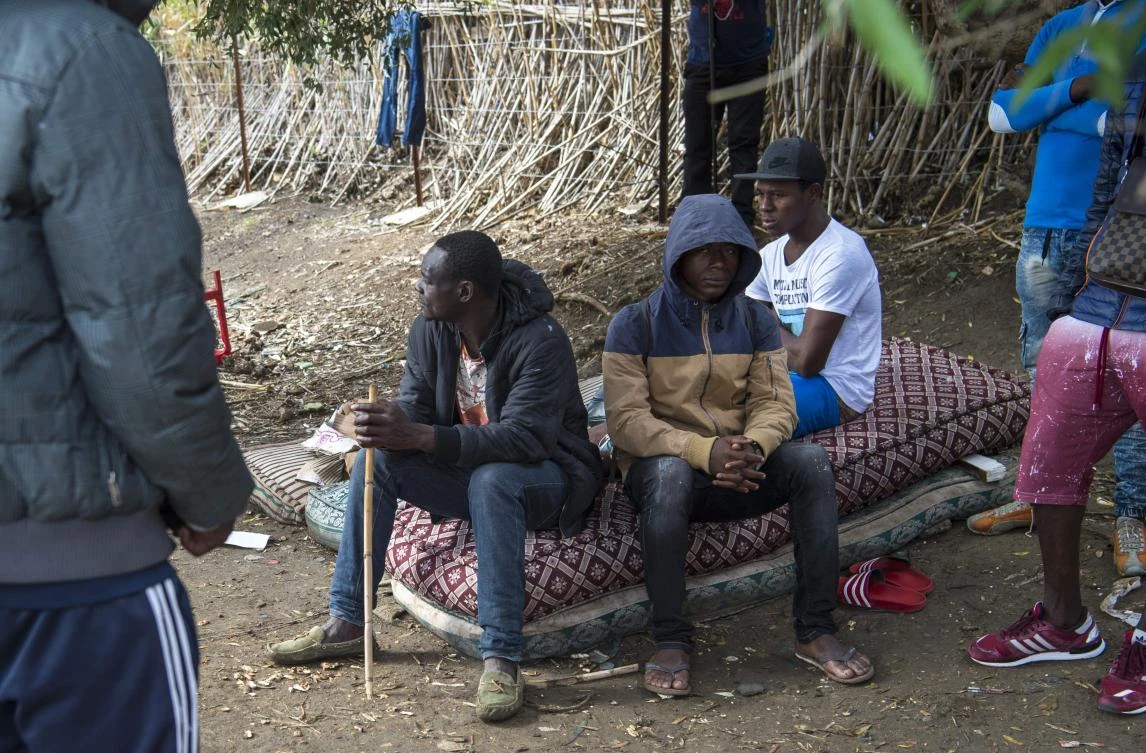 Migrants from Sub-Saharan Africa take shelter while hiding from the police in a forest in the district of Boukhalef, on the southwestern outskirts of the Moroccan port city of Tangiers which overlooks the Strait of Gibraltar, on October 20, 2018. (AFP)