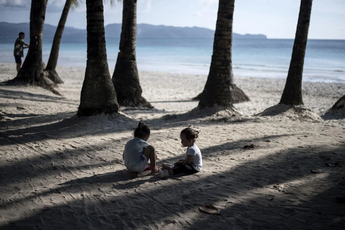Children play in a beach on the Philippine island of Boracay on October 25, 2018. The Philippines re-opens its crown jewel resort island Boracay to holidaymakers on October 26, after a six-month clean up aimed at repairing the damage inflicted by years of unrestrained mass tourism. / AFP / NOEL CELIS