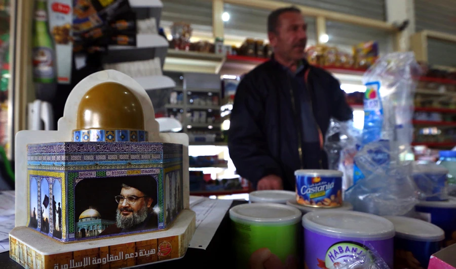 A piggy bank with a photo of Hezbollah leader, Sayyed Hassan Nasrallah, is displayed to collect money for the militant group, in the southern Lebanese village of Kfar Rumman, Lebanon. (AP File Photo)