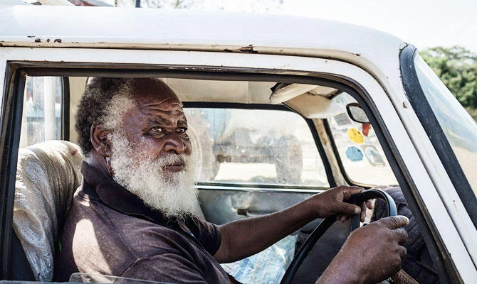 72-year-old Samson, a villager of universal basic income study, drives his car in Bondo region, western Kenya, on October 3, 2018. (AFP)