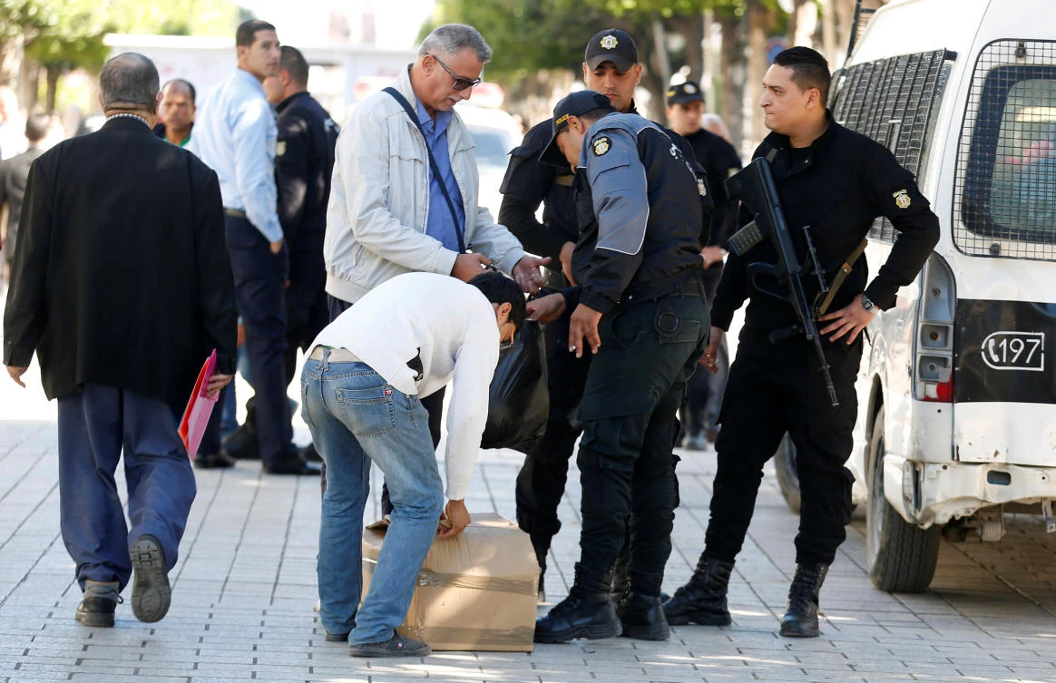 Policemen search civilians' belongings at the site of an explosion that occurred yesterday in Tunis, Tunisia October 30, 2018. (Reuters)