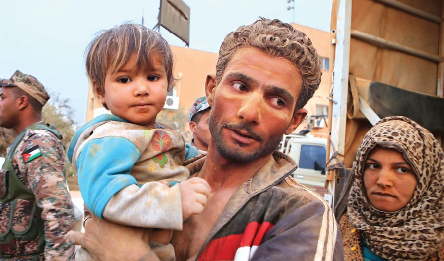 Syrian refugees covered in dust arrive at the Trabeel border after crossing into Jordanian territory from Syria. (AP/File)