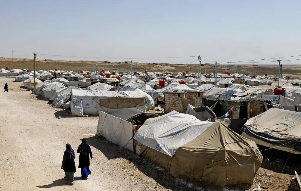 Women walk at a camp for Daesh group-affiliated people in the northern Syrian village of Malikiya near the border with Turkey, walks with a child on September 29, 2018. (File/AFP)