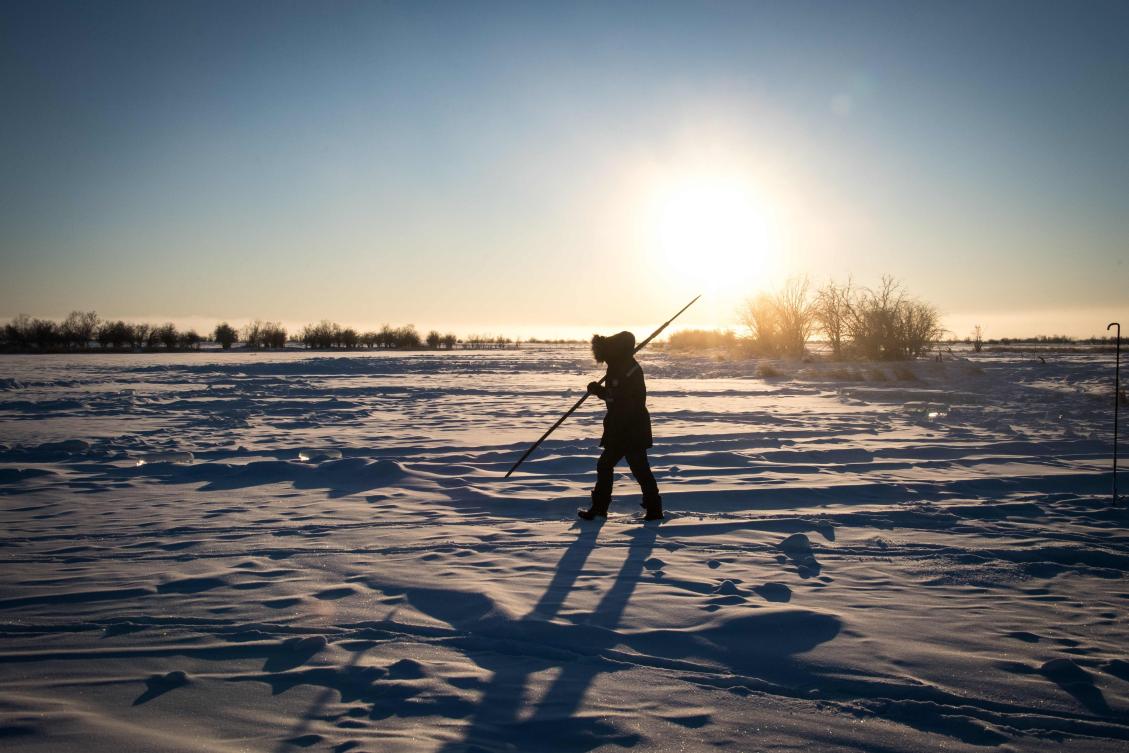 Villagers harvest ice from a local lake near the settlement of Oy, some 70 km south of Yakutsk, with the air temperature at about minus 41 degrees Celsius, on November 27, 2018. Many people in the Sakha (Yakutia) Republic depend on melted water as there is no other way to supply water due to extremely cold winter temperatures in the permafrost-covered region. / AFP / Mladen ANTONOV
