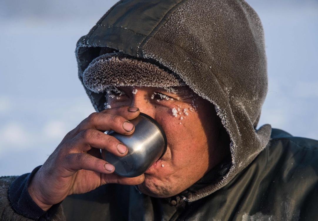 Villagers harvest ice from a local lake near the settlement of Oy, some 70 km south of Yakutsk, with the air temperature at about minus 41 degrees Celsius, on November 27, 2018. Many people in the Sakha (Yakutia) Republic depend on melted water as there is no other way to supply water due to extremely cold winter temperatures in the permafrost-covered region. / AFP / Mladen ANTONOV