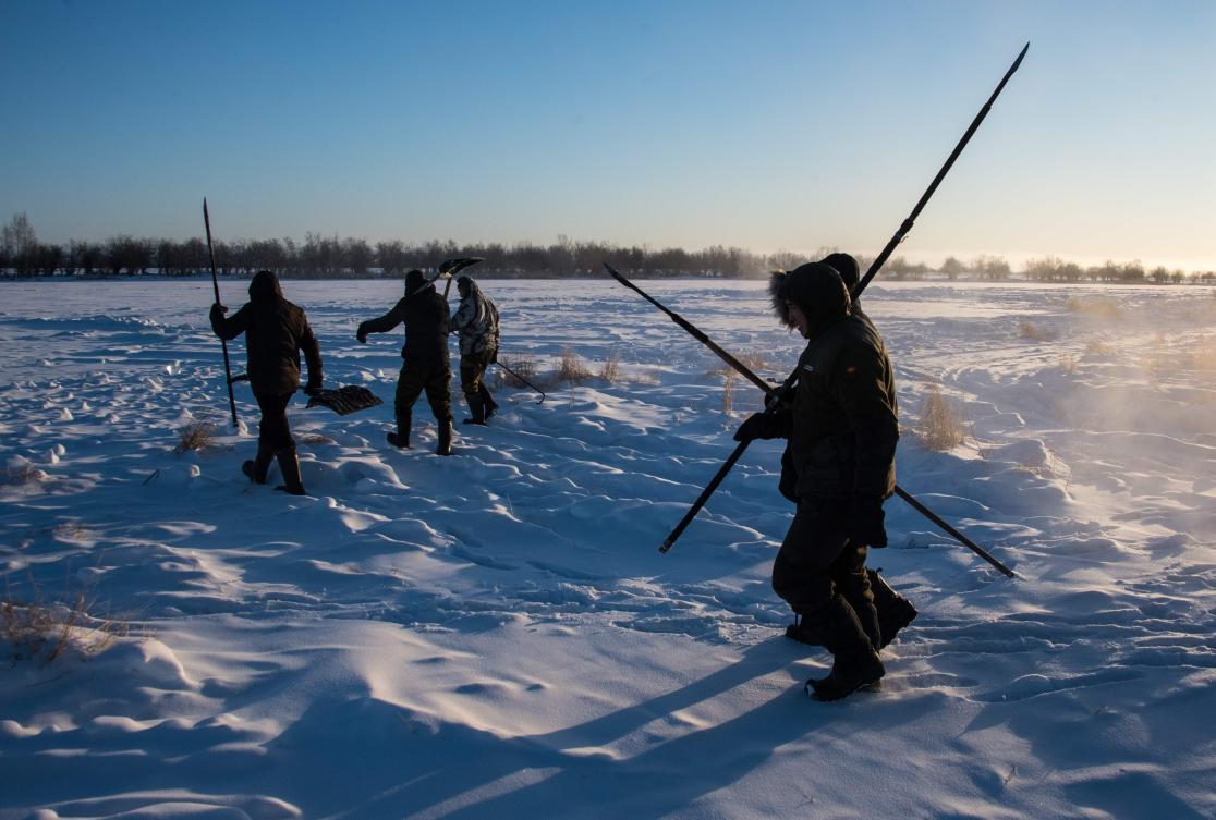 Villagers harvest ice from a local lake near the settlement of Oy, some 70 km south of Yakutsk, with the air temperature at about minus 41 degrees Celsius, on November 27, 2018. Many people in the Sakha (Yakutia) Republic depend on melted water as there is no other way to supply water due to extremely cold winter temperatures in the permafrost-covered region. / AFP / Mladen ANTONOV