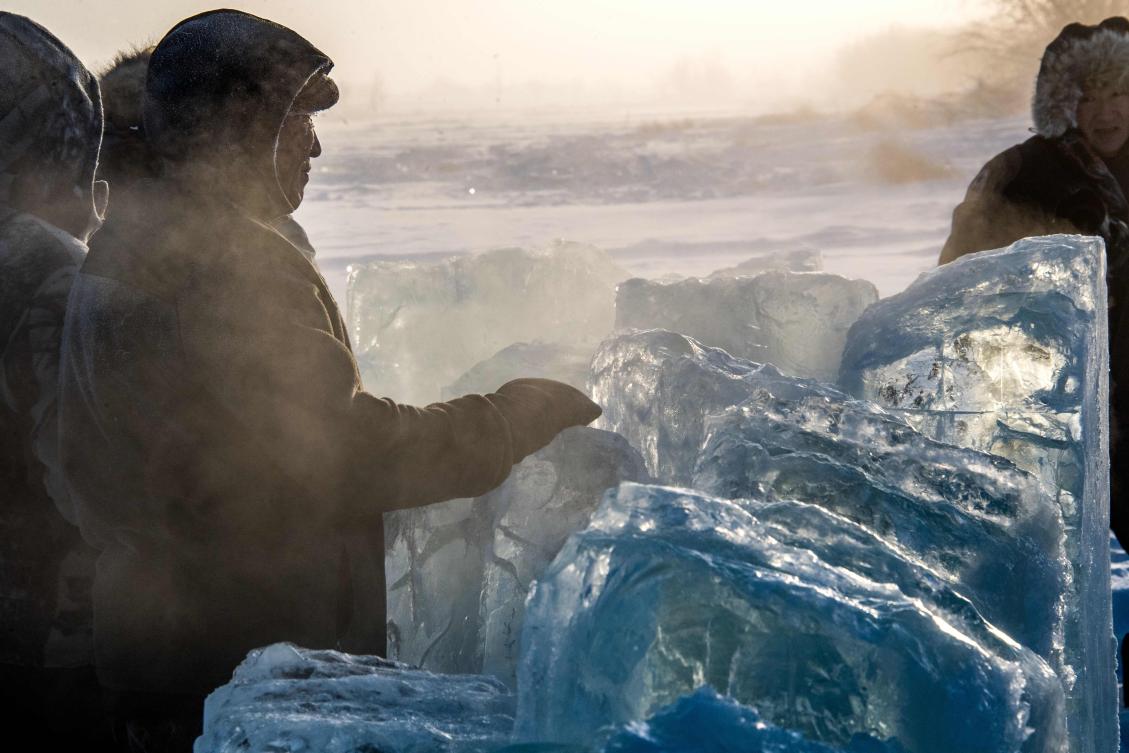 Villagers harvest ice from a local lake near the settlement of Oy, some 70 km south of Yakutsk, with the air temperature at about minus 41 degrees Celsius, on November 27, 2018. Many people in the Sakha (Yakutia) Republic depend on melted water as there is no other way to supply water due to extremely cold winter temperatures in the permafrost-covered region. / AFP / Mladen ANTONOV