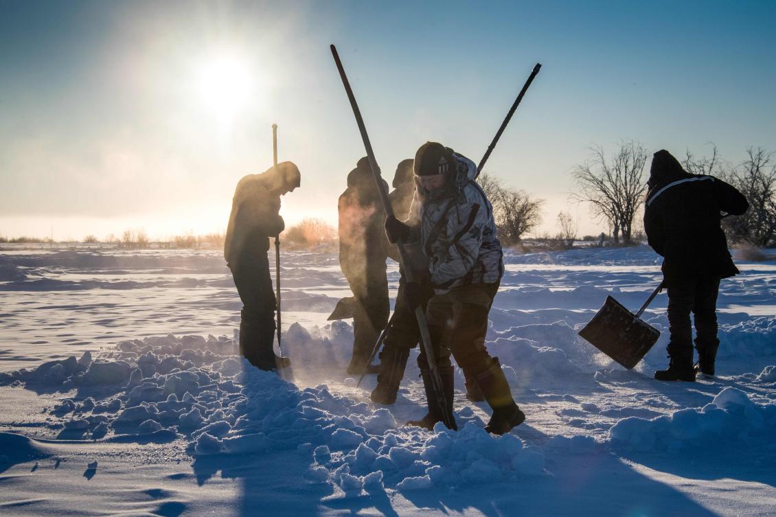 Villagers harvest ice from a local lake near the settlement of Oy, some 70 km south of Yakutsk, with the air temperature at about minus 41 degrees Celsius, on November 27, 2018. Many people in the Sakha (Yakutia) Republic depend on melted water as there is no other way to supply water due to extremely cold winter temperatures in the permafrost-covered region. / AFP / Mladen ANTONOV