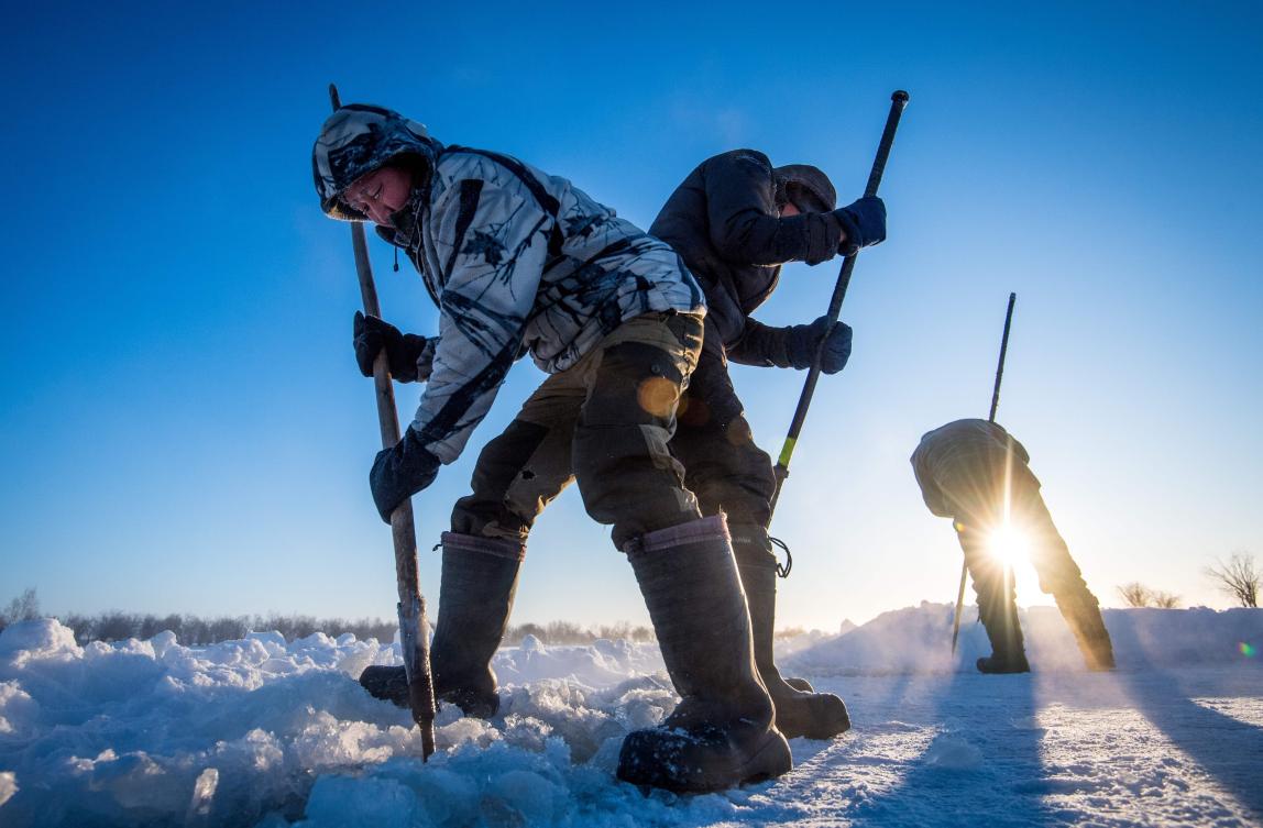 Villagers harvest ice from a local lake near the settlement of Oy, some 70 km south of Yakutsk, with the air temperature at about minus 41 degrees Celsius, on November 27, 2018. Many people in the Sakha (Yakutia) Republic depend on melted water as there is no other way to supply water due to extremely cold winter temperatures in the permafrost-covered region. / AFP / Mladen ANTONOV