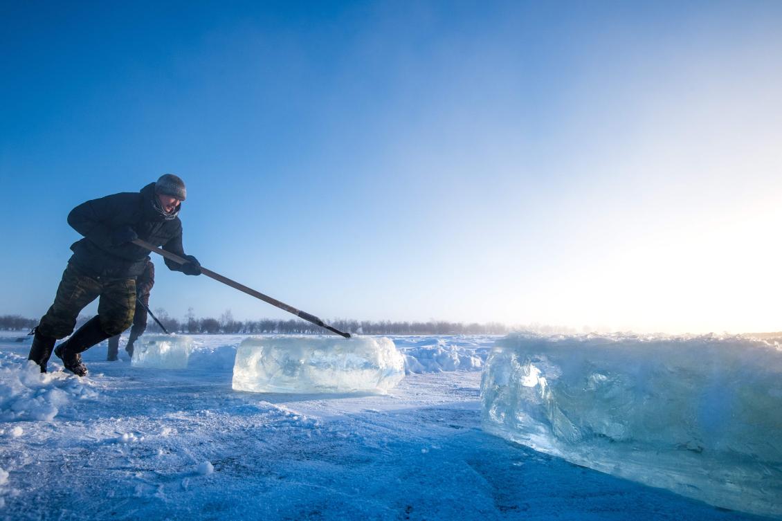 Villagers harvest ice from a local lake near the settlement of Oy, some 70 km south of Yakutsk, with the air temperature at about minus 41 degrees Celsius, on November 27, 2018. Many people in the Sakha (Yakutia) Republic depend on melted water as there is no other way to supply water due to extremely cold winter temperatures in the permafrost-covered region. / AFP / Mladen ANTONOV