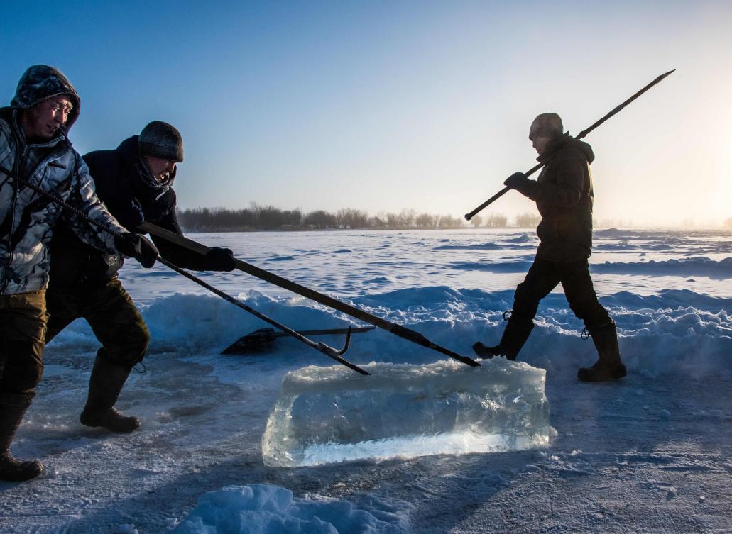 Villagers harvest ice from a local lake near the settlement of Oy, some 70 km south of Yakutsk, with the air temperature at about minus 41 degrees Celsius, on November 27, 2018. Many people in the Sakha (Yakutia) Republic depend on melted water as there is no other way to supply water due to extremely cold winter temperatures in the permafrost-covered region. / AFP / Mladen ANTONOV