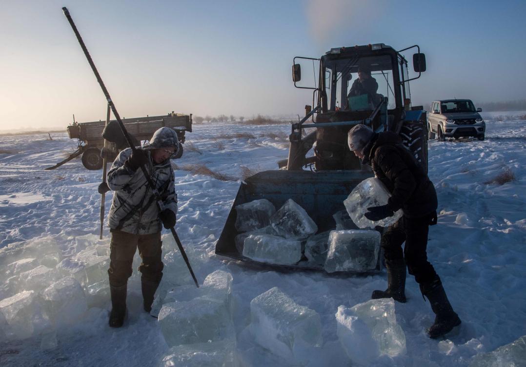 Villagers harvest ice from a local lake near the settlement of Oy, some 70 km south of Yakutsk, with the air temperature at about minus 41 degrees Celsius, on November 27, 2018. Many people in the Sakha (Yakutia) Republic depend on melted water as there is no other way to supply water due to extremely cold winter temperatures in the permafrost-covered region. / AFP / Mladen ANTONOV