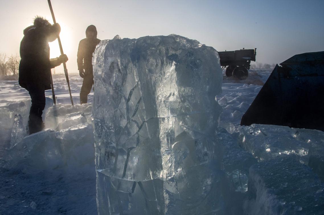 Villagers harvest ice from a local lake near the settlement of Oy, some 70 km south of Yakutsk, with the air temperature at about minus 41 degrees Celsius, on November 27, 2018. Many people in the Sakha (Yakutia) Republic depend on melted water as there is no other way to supply water due to extremely cold winter temperatures in the permafrost-covered region. / AFP / Mladen ANTONOV