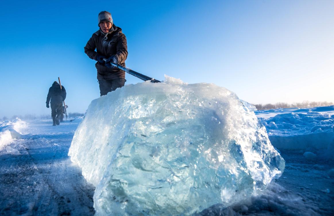 Villagers harvest ice from a local lake near the settlement of Oy, some 70 km south of Yakutsk, with the air temperature at about minus 41 degrees Celsius, on November 27, 2018. Many people in the Sakha (Yakutia) Republic depend on melted water as there is no other way to supply water due to extremely cold winter temperatures in the permafrost-covered region. / AFP / Mladen ANTONOV