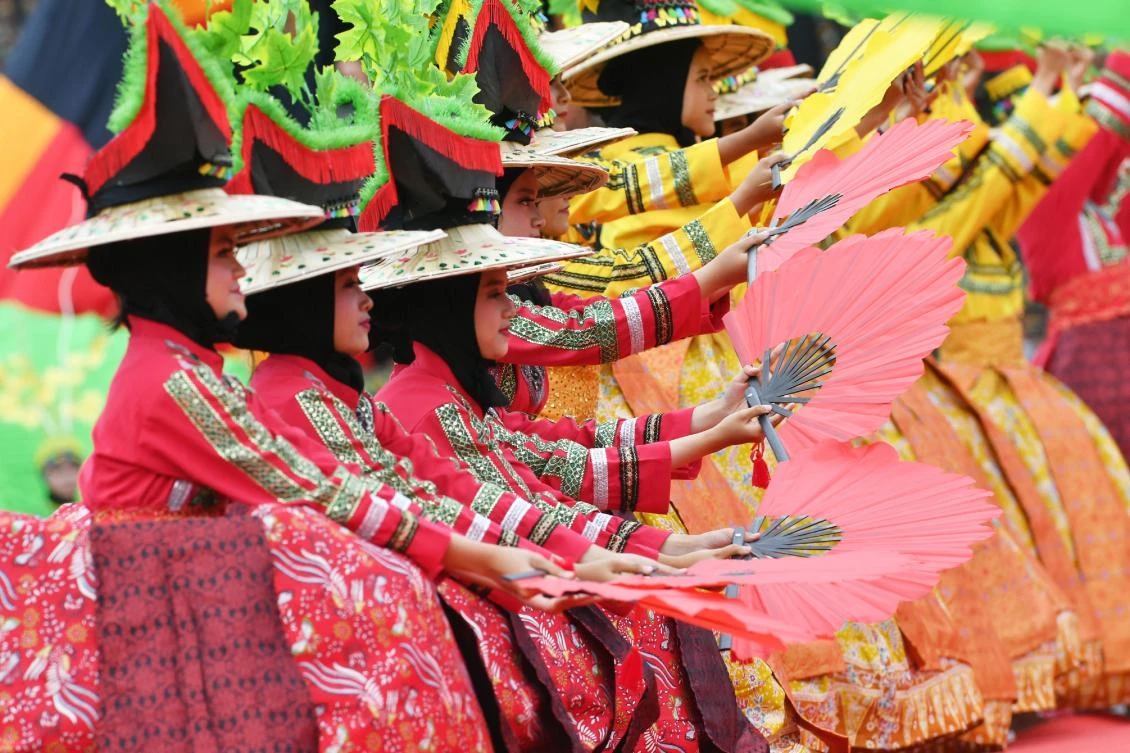 Indonesian dancers participate at the 2018 Minangkabau art and culture festival in Batusangkar, West Sumatra with the Istano Basa Pagaruyuang at the background on November 28, 2018. The 2018 Minangkabau art and culture festival featuring variety of Minangkabau - one of Indonesia's ethnics - arts and culture that is held in Tanah Datar regency from November 28 - December 2 to boost both economy and tourism. / AFP / ADEK BERRY
