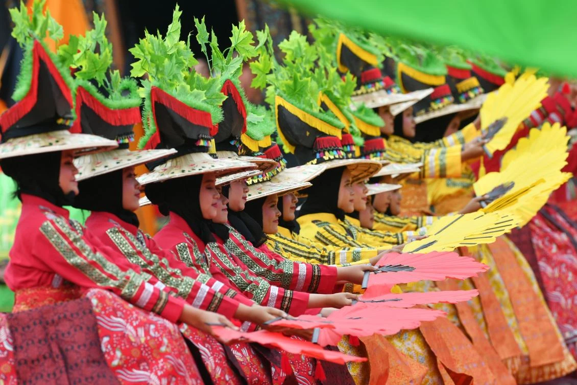 Indonesian dancers participate at the 2018 Minangkabau art and culture festival in Batusangkar, West Sumatra with the Istano Basa Pagaruyuang at the background on November 28, 2018. The 2018 Minangkabau art and culture festival featuring variety of Minangkabau - one of Indonesia's ethnics - arts and culture that is held in Tanah Datar regency from November 28 - December 2 to boost both economy and tourism. / AFP / ADEK BERRY