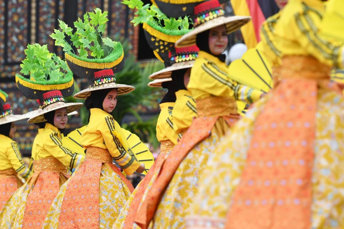 Indonesian dancers participate at the 2018 Minangkabau art and culture festival in Batusangkar, West Sumatra with the Istano Basa Pagaruyuang at the background on November 28, 2018. The 2018 Minangkabau art and culture festival featuring variety of Minangkabau - one of Indonesia's ethnics - arts and culture that is held in Tanah Datar regency from November 28 - December 2 to boost both economy and tourism. / AFP / ADEK BERRY