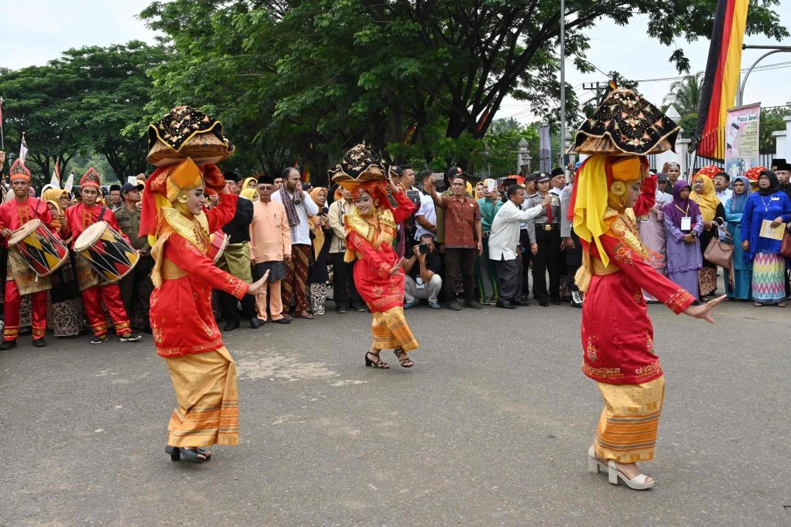 Indonesian dancers in Minangkabau traditional outfits welcome guests at the 2018 Minangkabau art and culture festival in Batusangkar, West Sumatra with the Istano Basa Pagaruyuang at the background on November 28, 2018. The 2018 Minangkabau art and culture festival featuring variety of Minangkabau - one of Indonesia's ethnics - arts and culture that is held in Tanah Datar regency from November 28 - December 2 to boost both economy and tourism. / AFP / ADEK BERRY